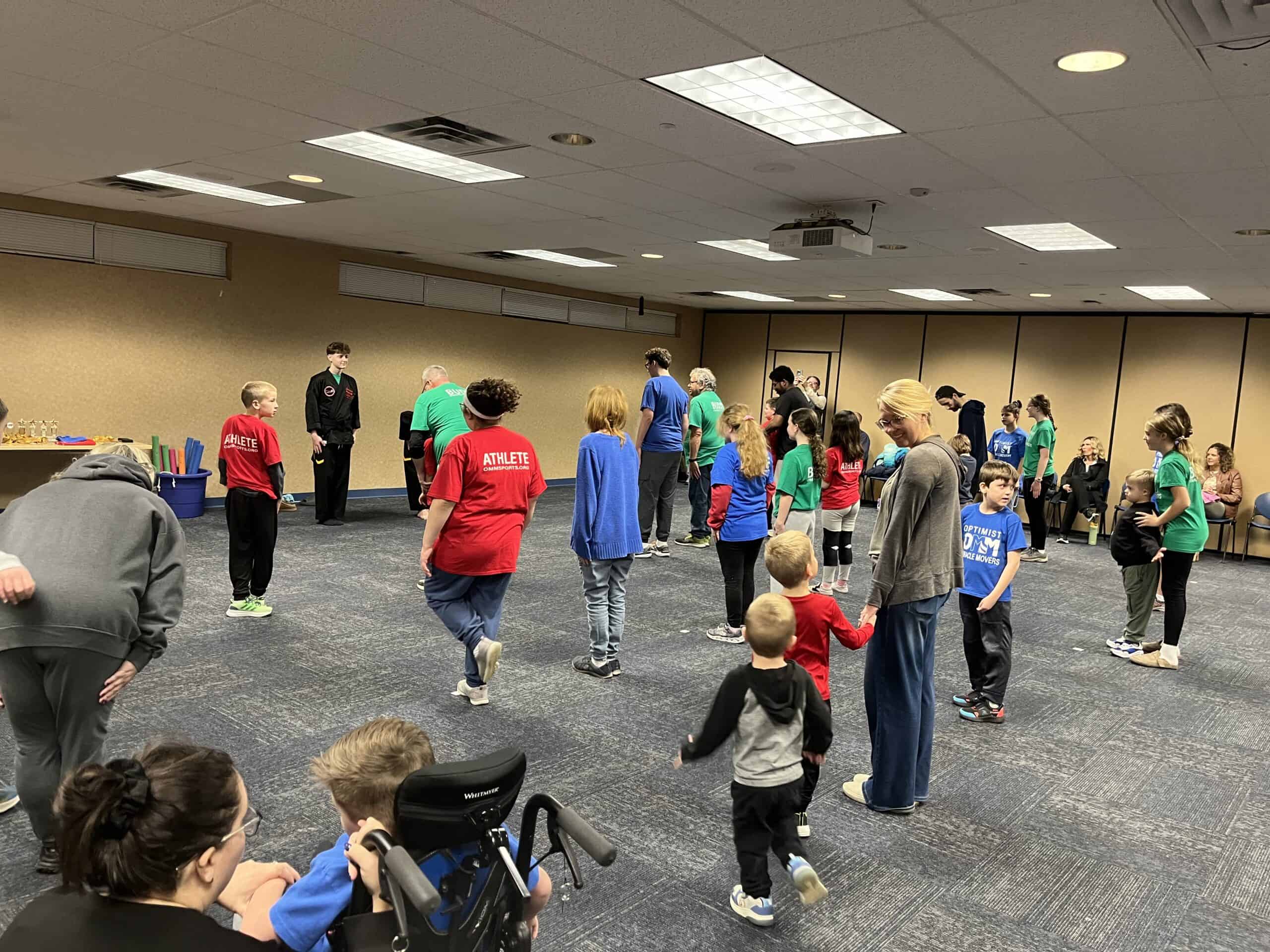 Martial arts class with children practicing techniques in a spacious indoor facility.