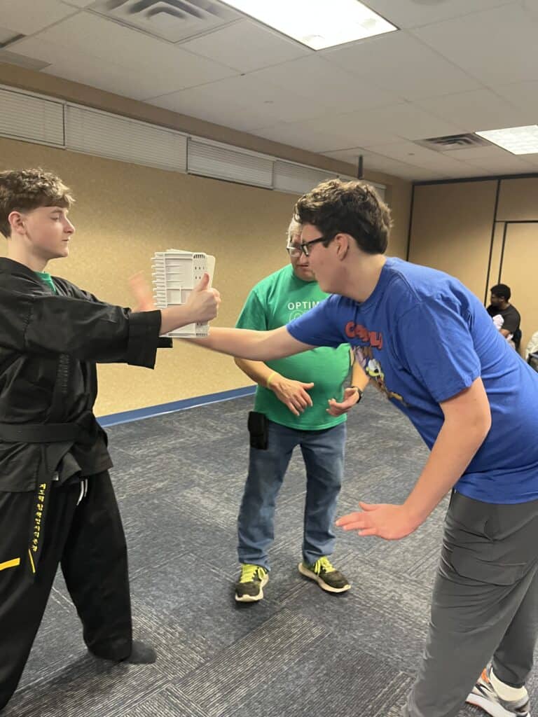 Kids practicing martial arts techniques indoors at Optimist Miracle Movers.