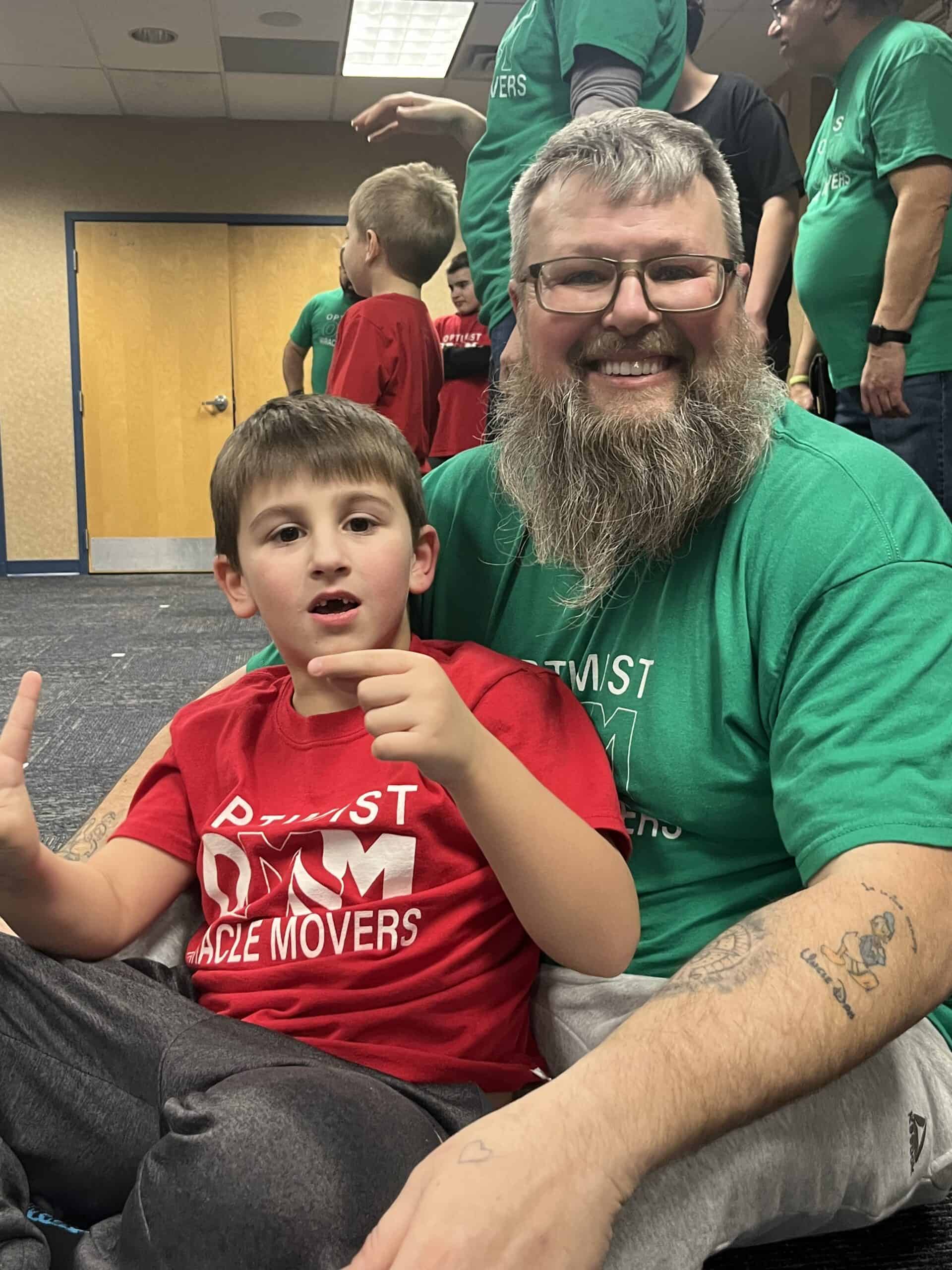 Optimist Miracle Movers team with children at martial arts event.