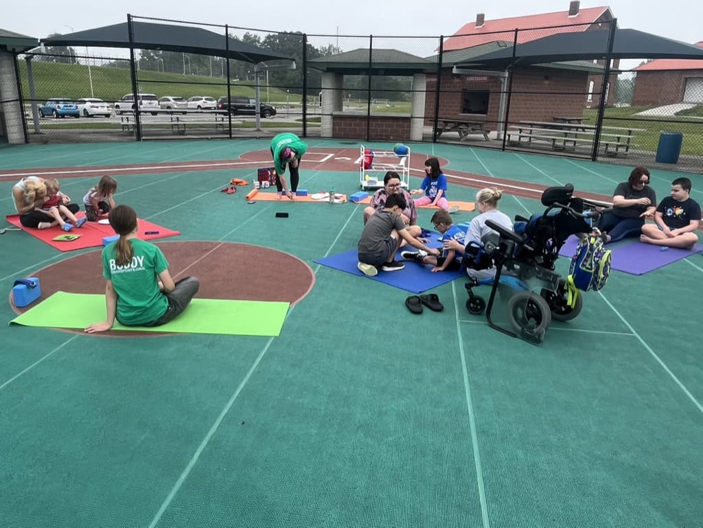 Accessible stretching and yoga session on a tennis court for individuals with diverse abilities.